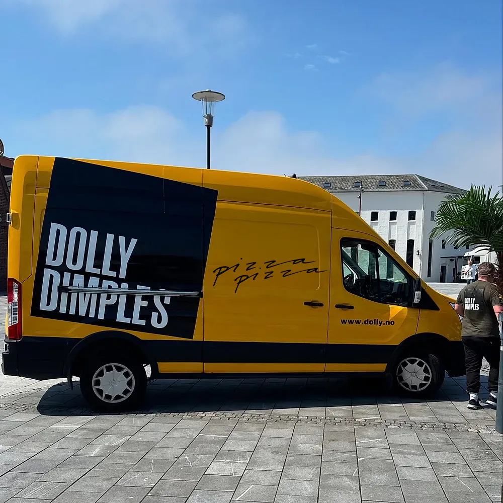 Den gule Dolly Dimples-varebilen med «pizza pizza» på siden